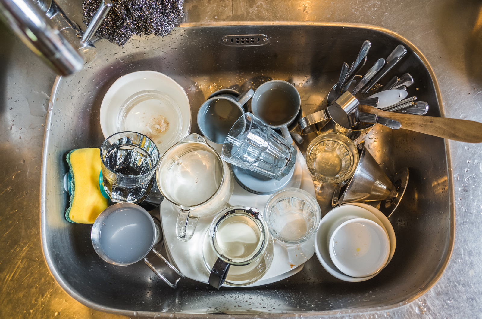 A kitchen sink full of dirty dishes