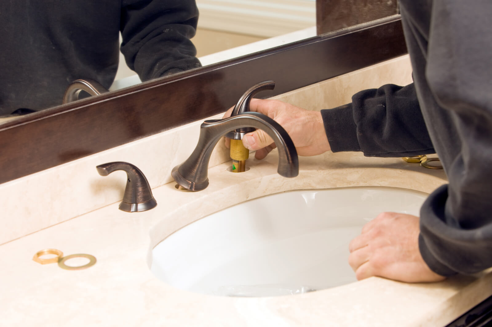 Someone installing the right handle on a bathroom faucet